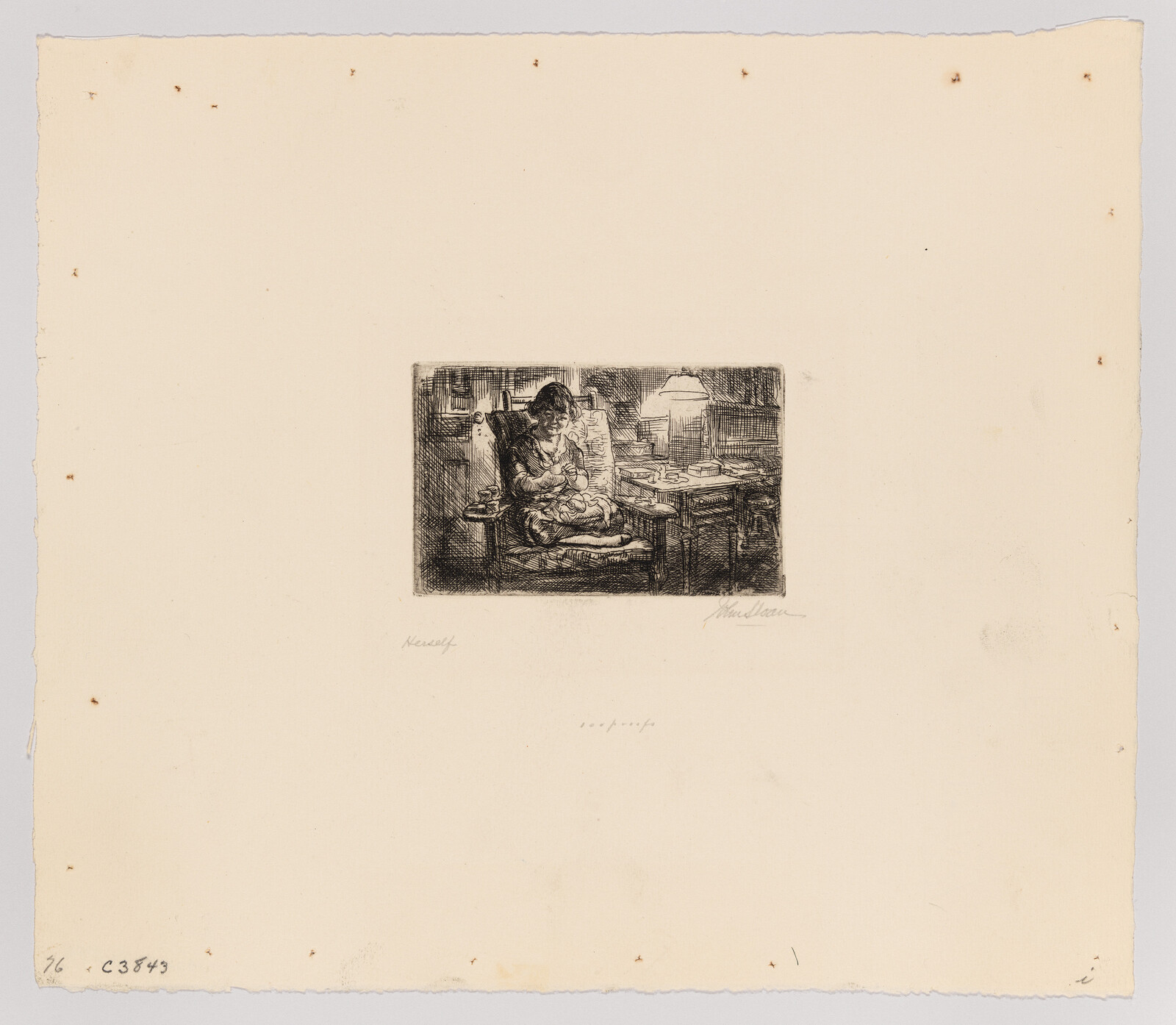 A woman sits in an armchair nursing and cradling a sleeping baby beside a lit table lamp.