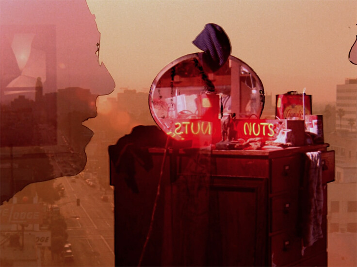 Dresser with round mirror reflecting a neon "NUTS" sign against a city skyline, overlaid by two profile silhouettes.