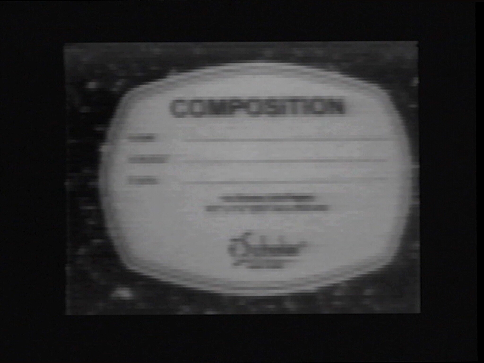 Blurry circular label centered on a dark background with the word 'COMPOSITION' and faint lines.