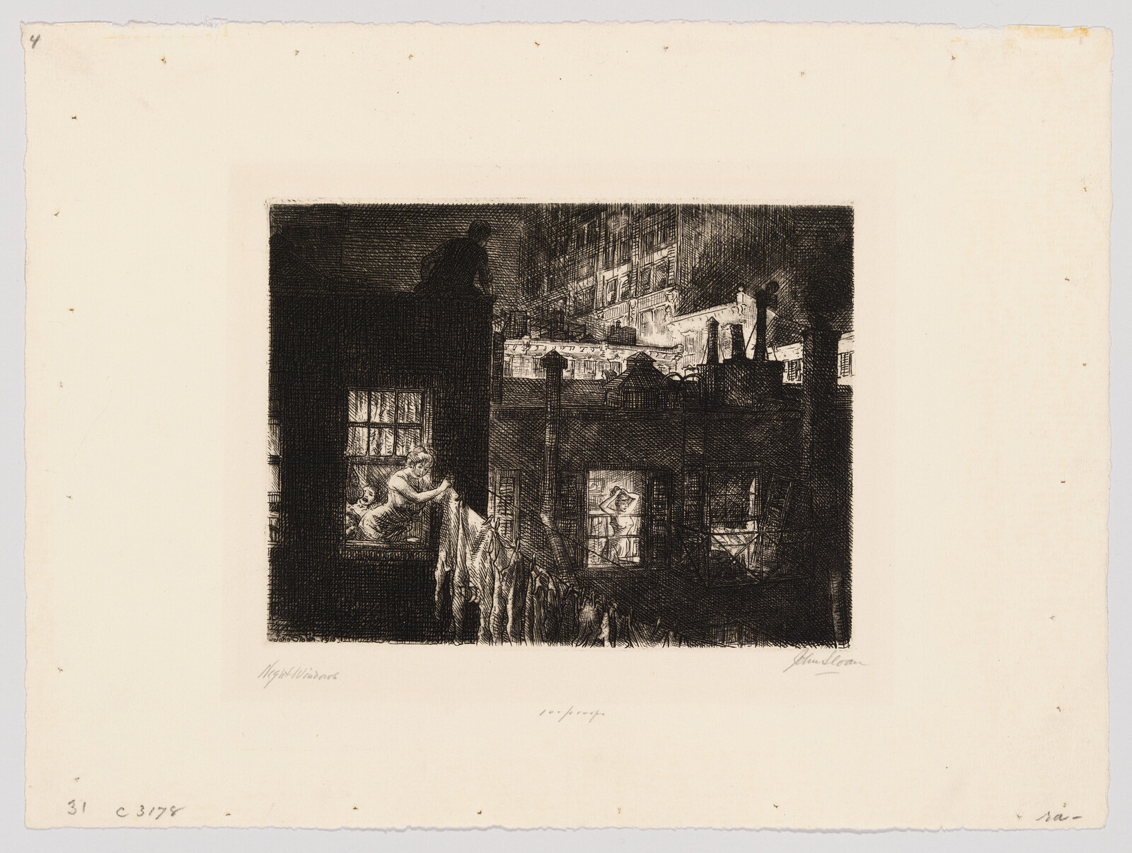 A woman leans out a lit window at night hanging laundry across a courtyard.