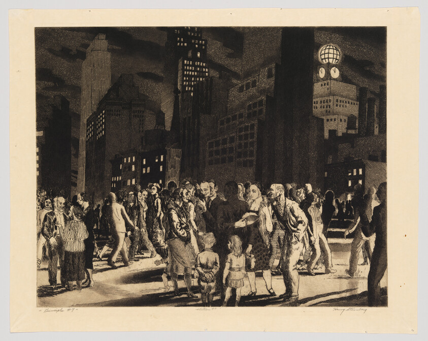 A crowd of people walk and gather on a city street at night under tall buildings.