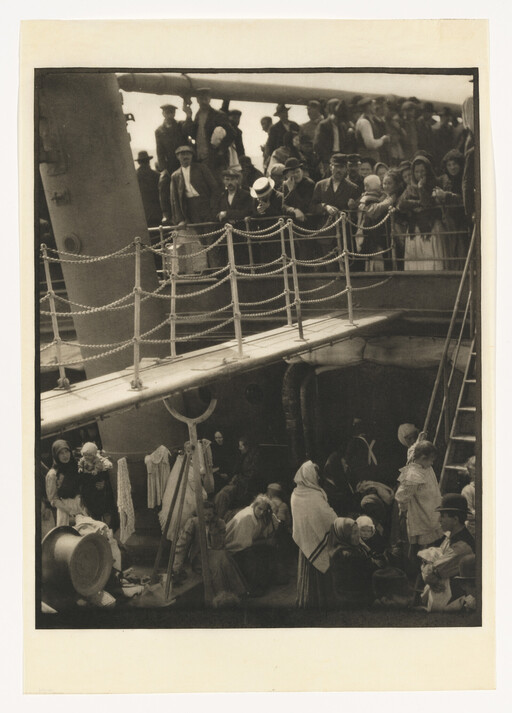 Crowd of passengers on a ship's deck and lower deck, many women and children gathered.