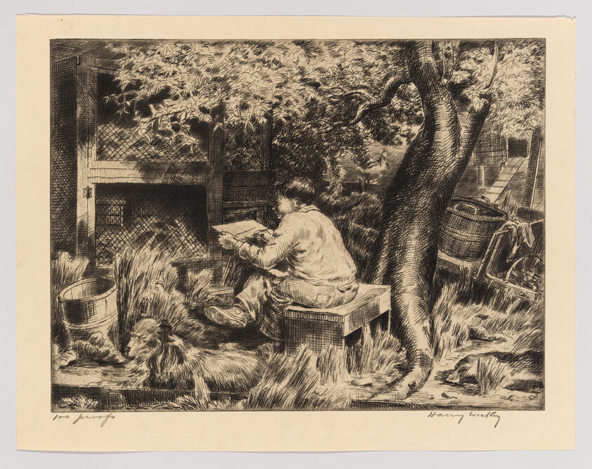 A boy sits on a wooden crate under a tree reading while a dog lies nearby.