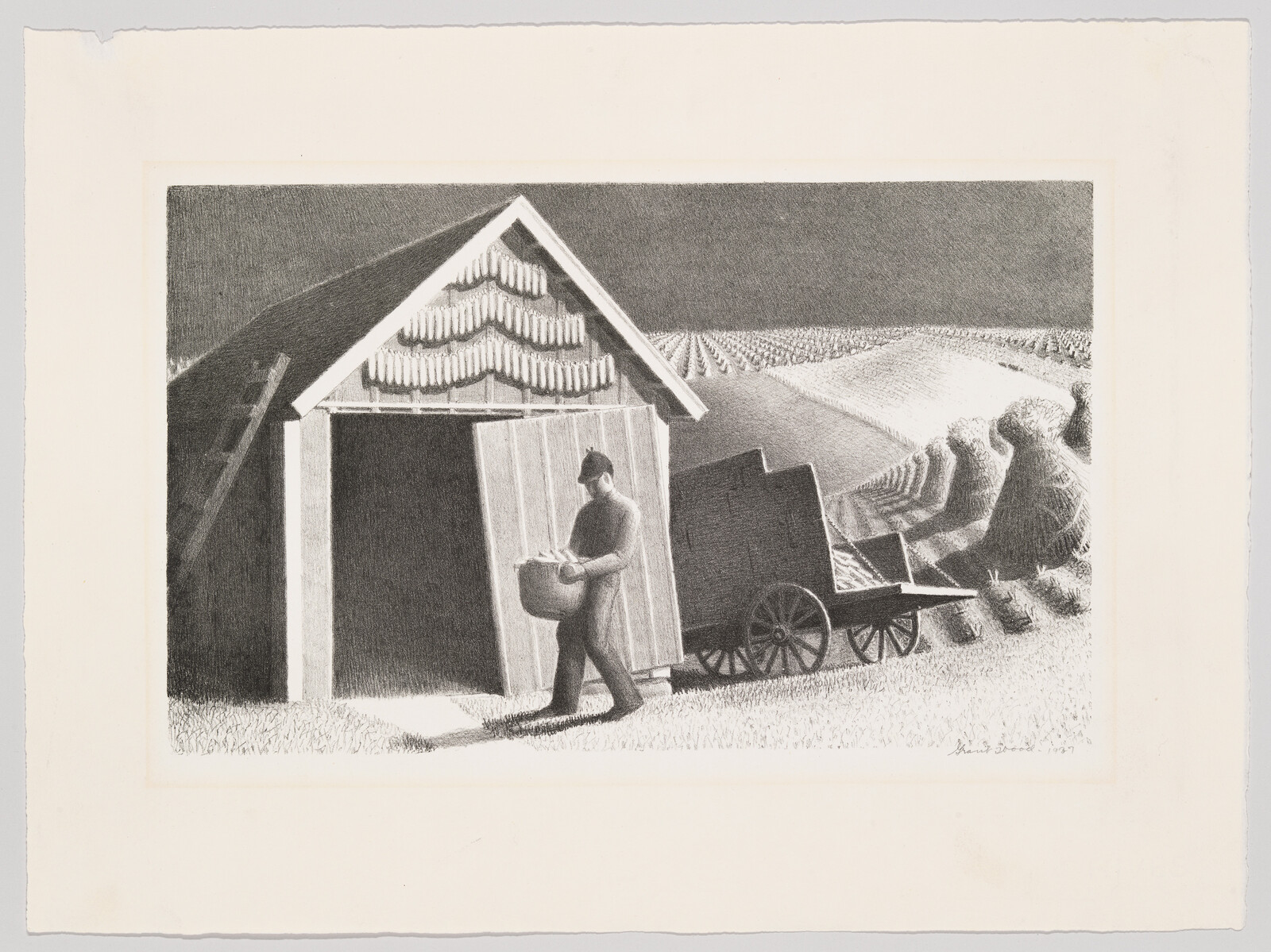 A man carries a basket out of a small barn beside a wagon with fields beyond.