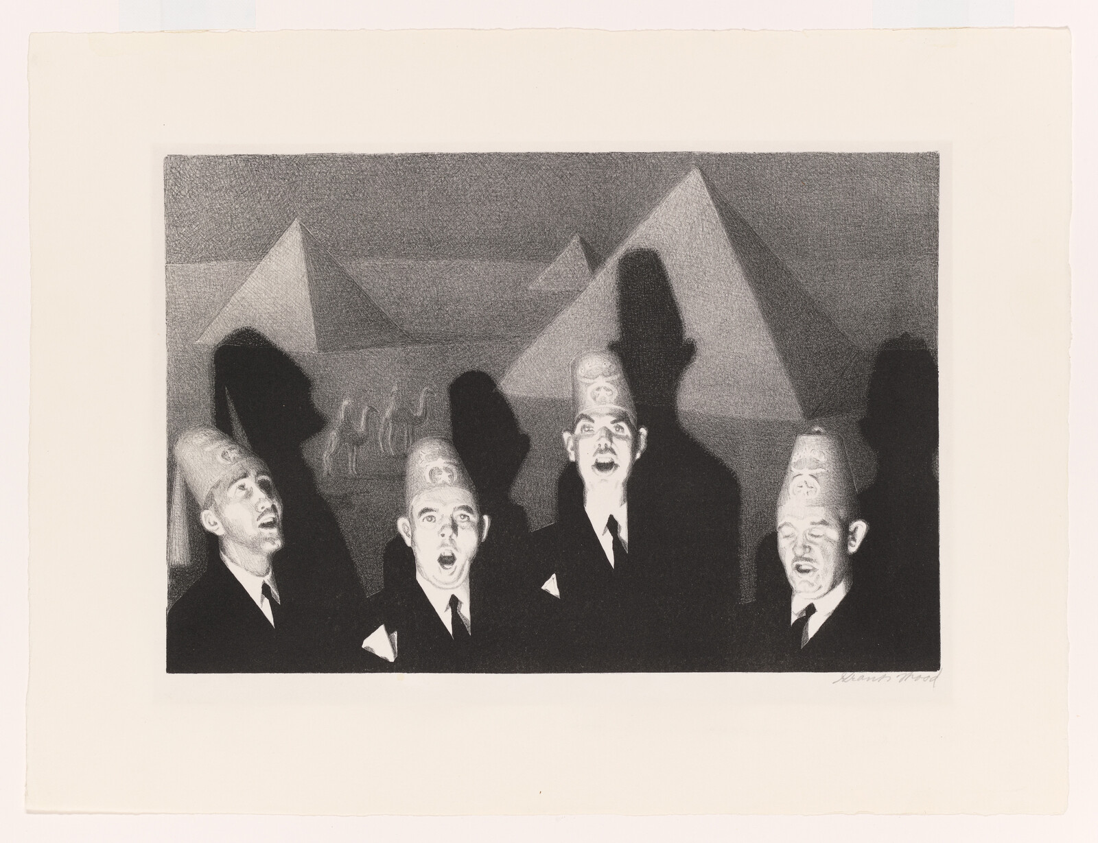 Four men in suits wearing fez hats sing together in front of pyramids, casting tall shadows.