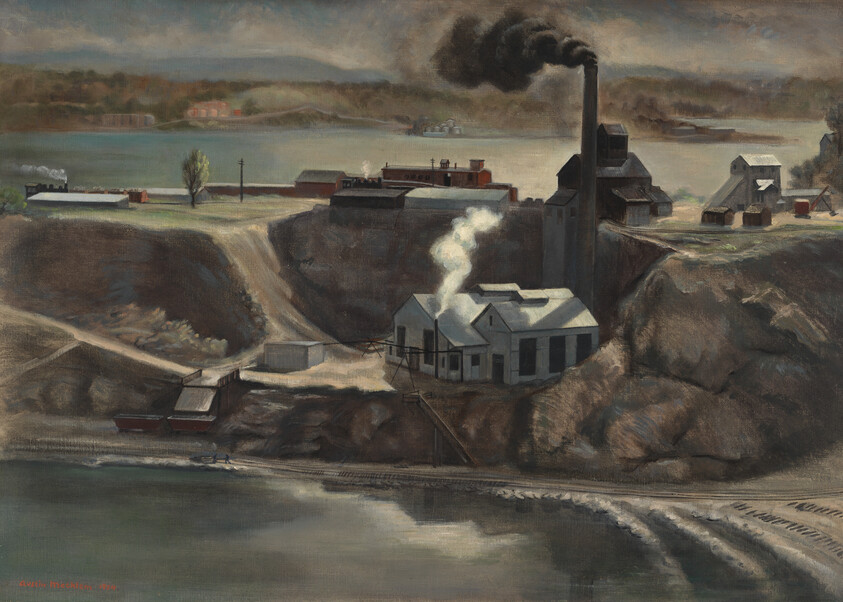 A riverside factory with a tall smokestack emitting black smoke beside steep cliffs and water.