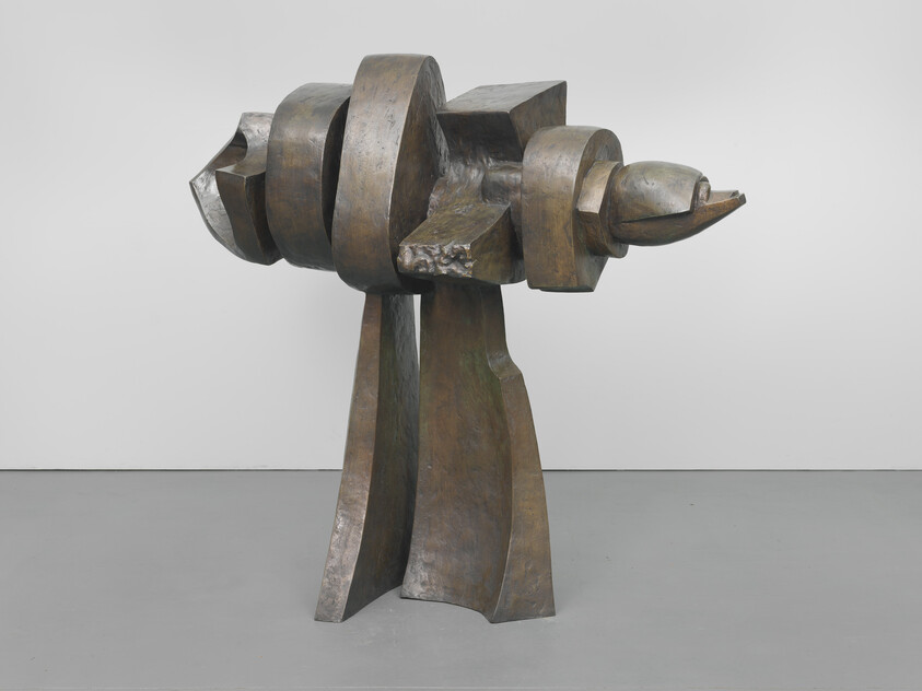 Bronze abstract sculpture with rounded horizontal forms balanced on two tall vertical legs.
