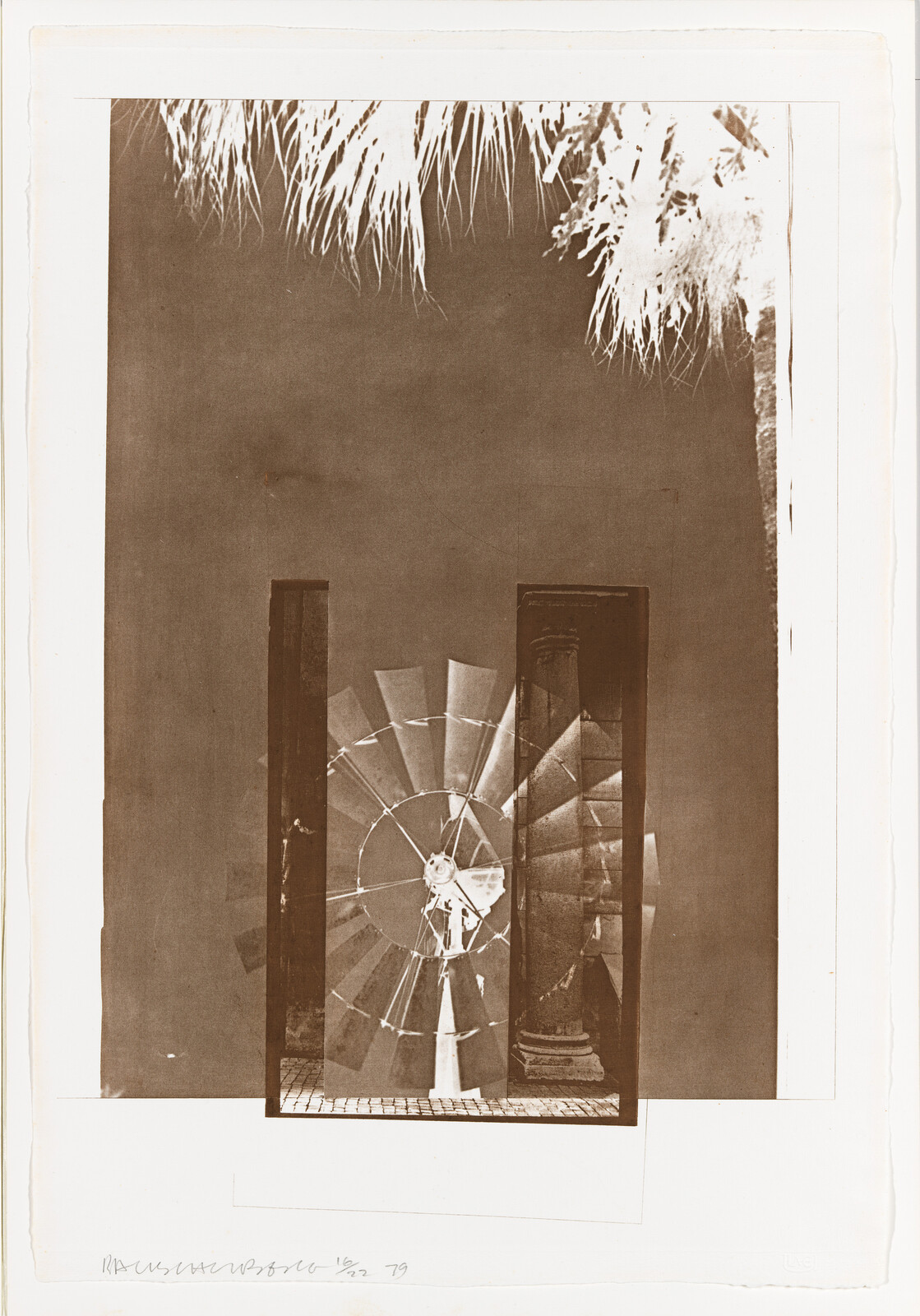 Large metal windmill wheel framed by a doorway with palm fronds visible above.