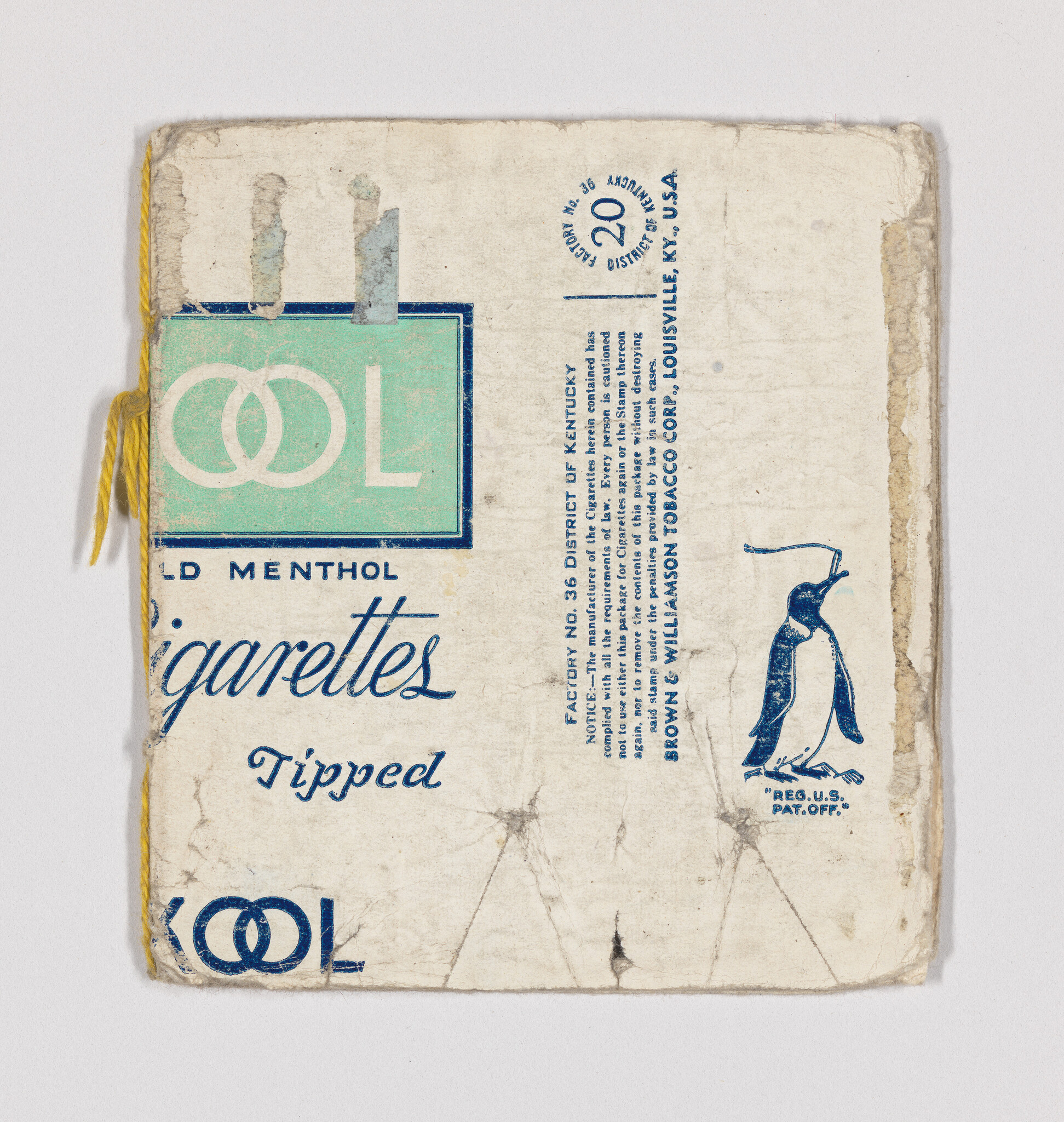 Worn menthol cigarette pack wrapper with penguin logo and yellow string tied along the edge.