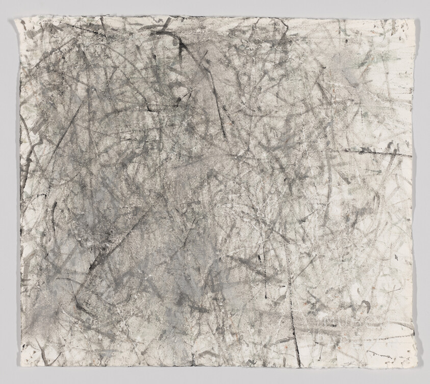 Large sheet of paper with chaotic gray and black charcoal scratches and smudges.