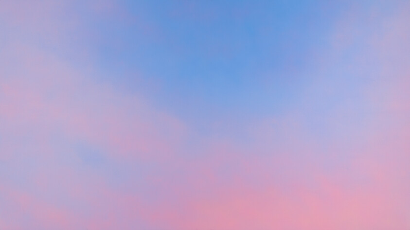 Soft blue and pink sky gradient at sunset with gentle cloud tones filling the frame.
