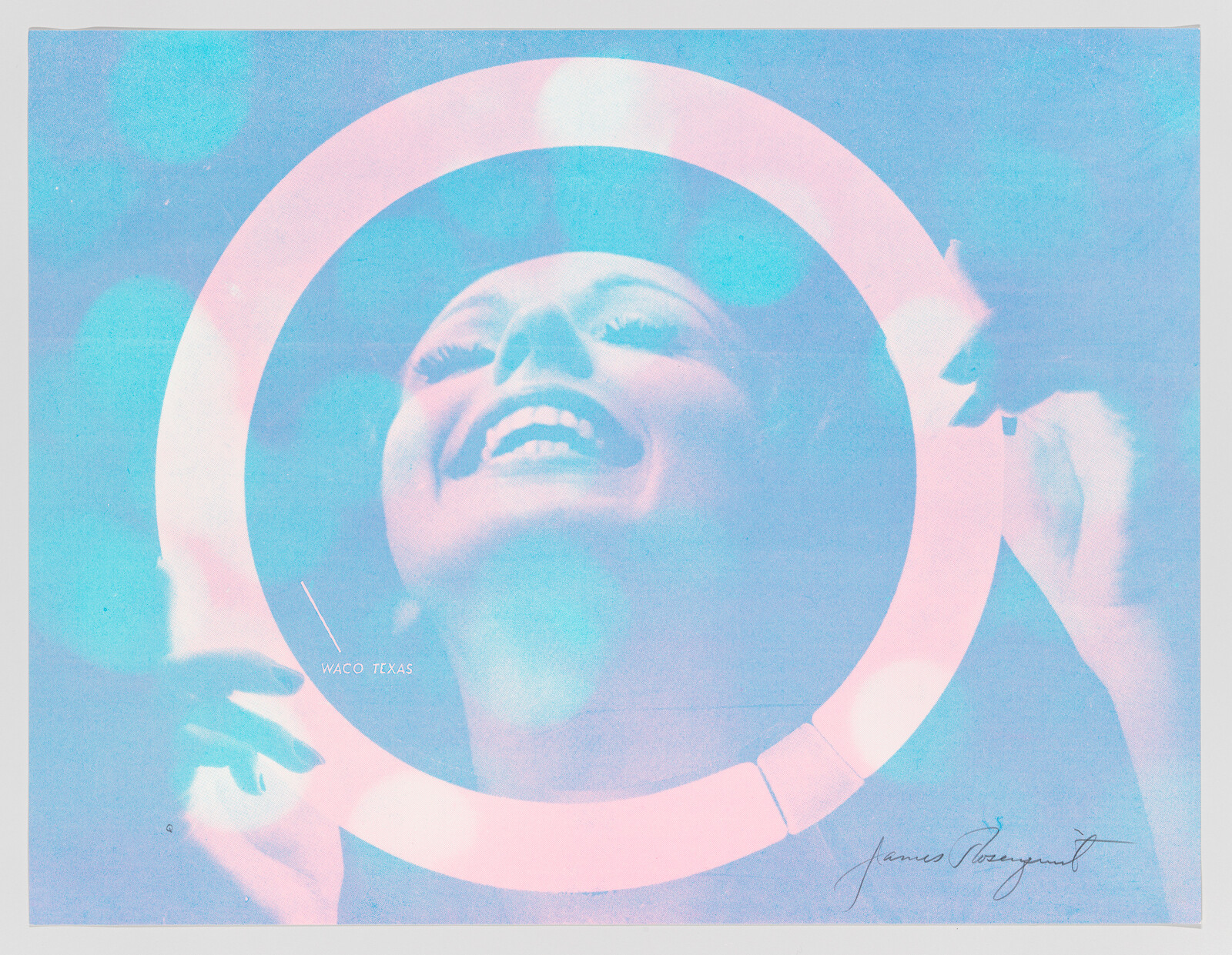 A smiling woman looks upward while her face is framed by a glowing circular ring.