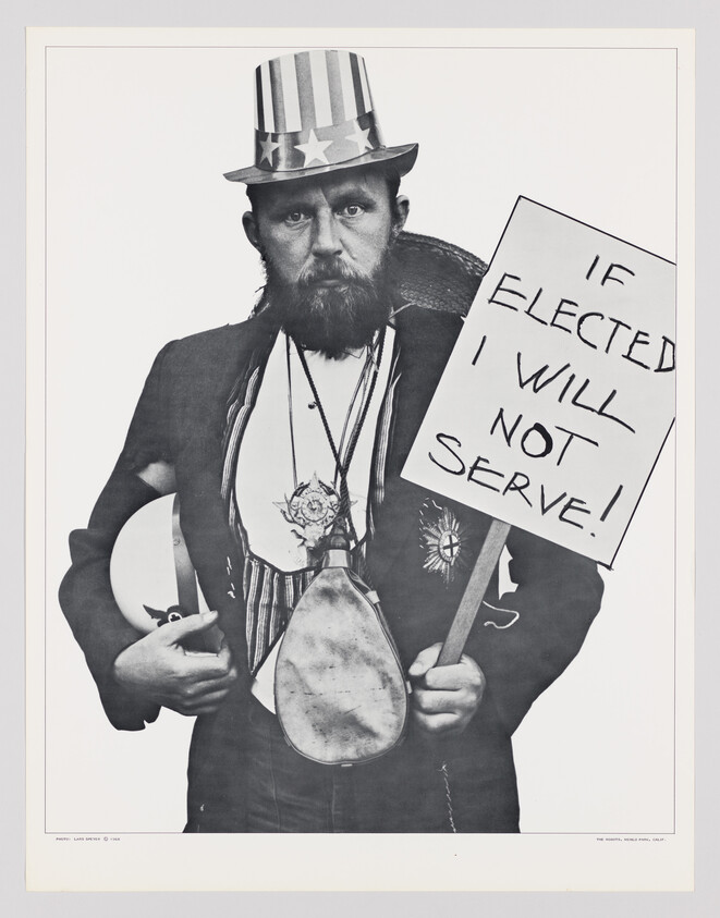 Black and white photograph of a person dressed in a costume resembling Uncle Sam, with a striped top hat and a beard, holding a sign that reads "IF ELECTED I WILL NOT SERVE!" The individual also wears a vest and a badge, and is holding a frying pan. The image has a satirical tone, likely commenting on political themes.