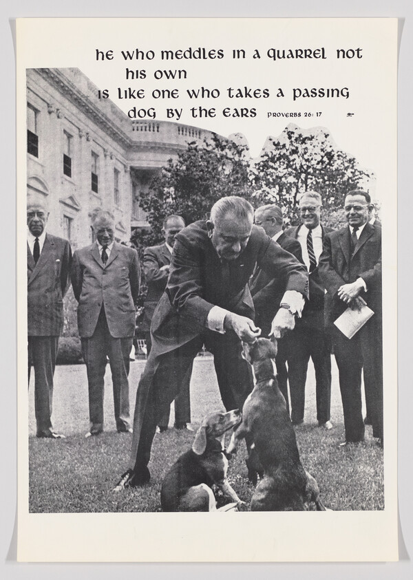 Man bending forward to grab a dog's ears while several suited men watch nearby.