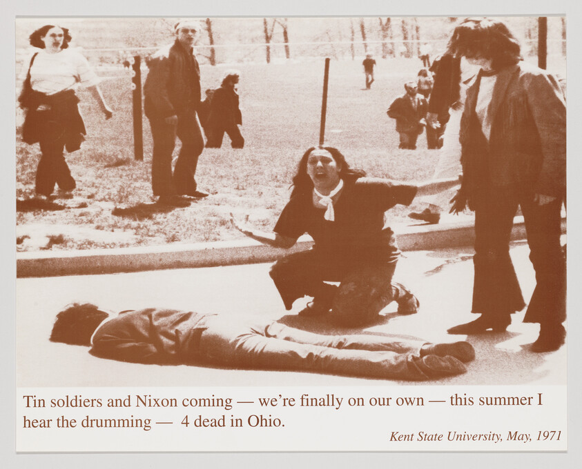 Woman kneels and cries beside a wounded student on the pavement after shootings at Kent State.
