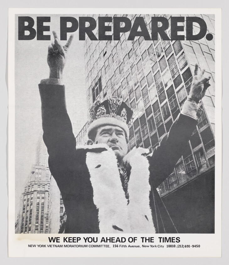 A man wearing a crown and fur robe raises both arms in a city beneath the words "Be prepared."