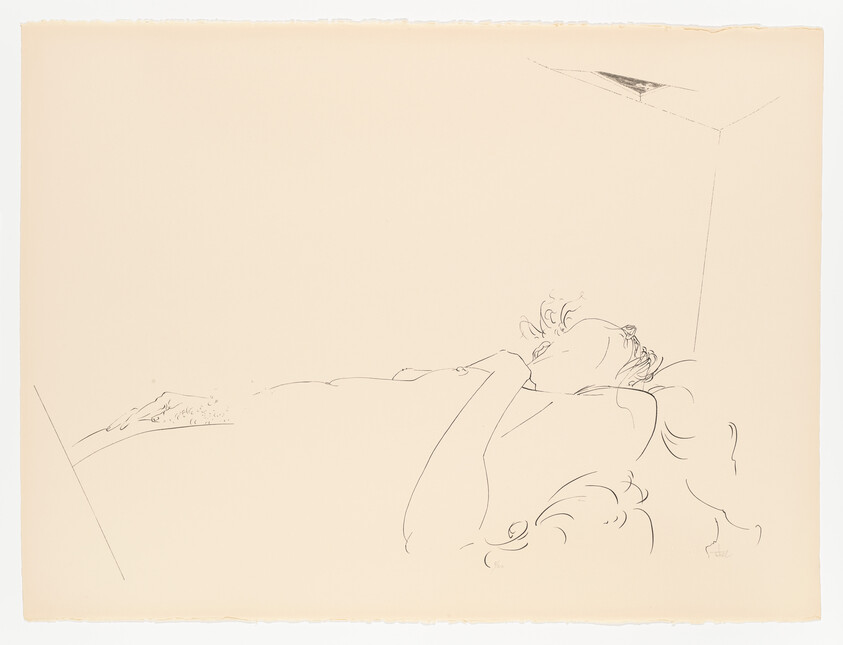 A person lies on their back with an arm across their chest in a sparse room.