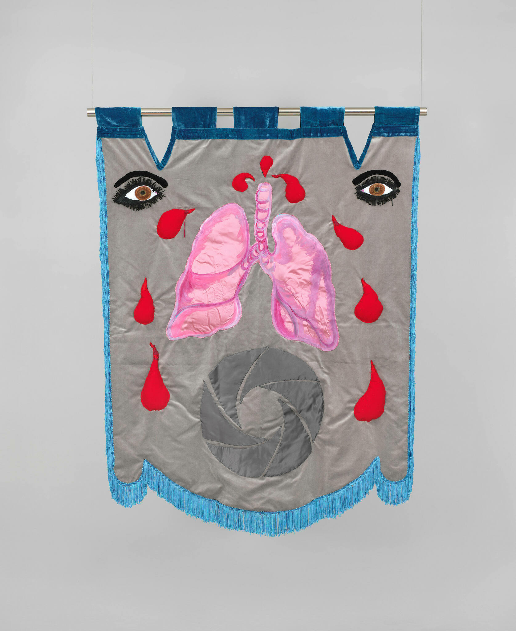 Lush fabric banner with eyelashed eyes framing pink lungs spurting blood droplets above geometric logo.