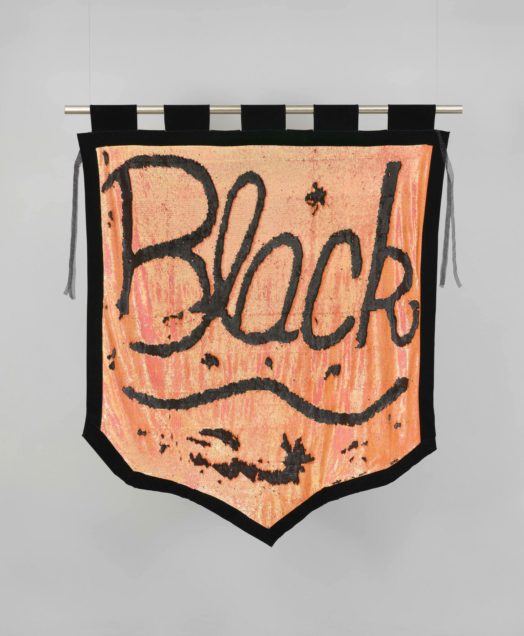 On a velvet orange banner with a black border, the word Black is written in script and underlined