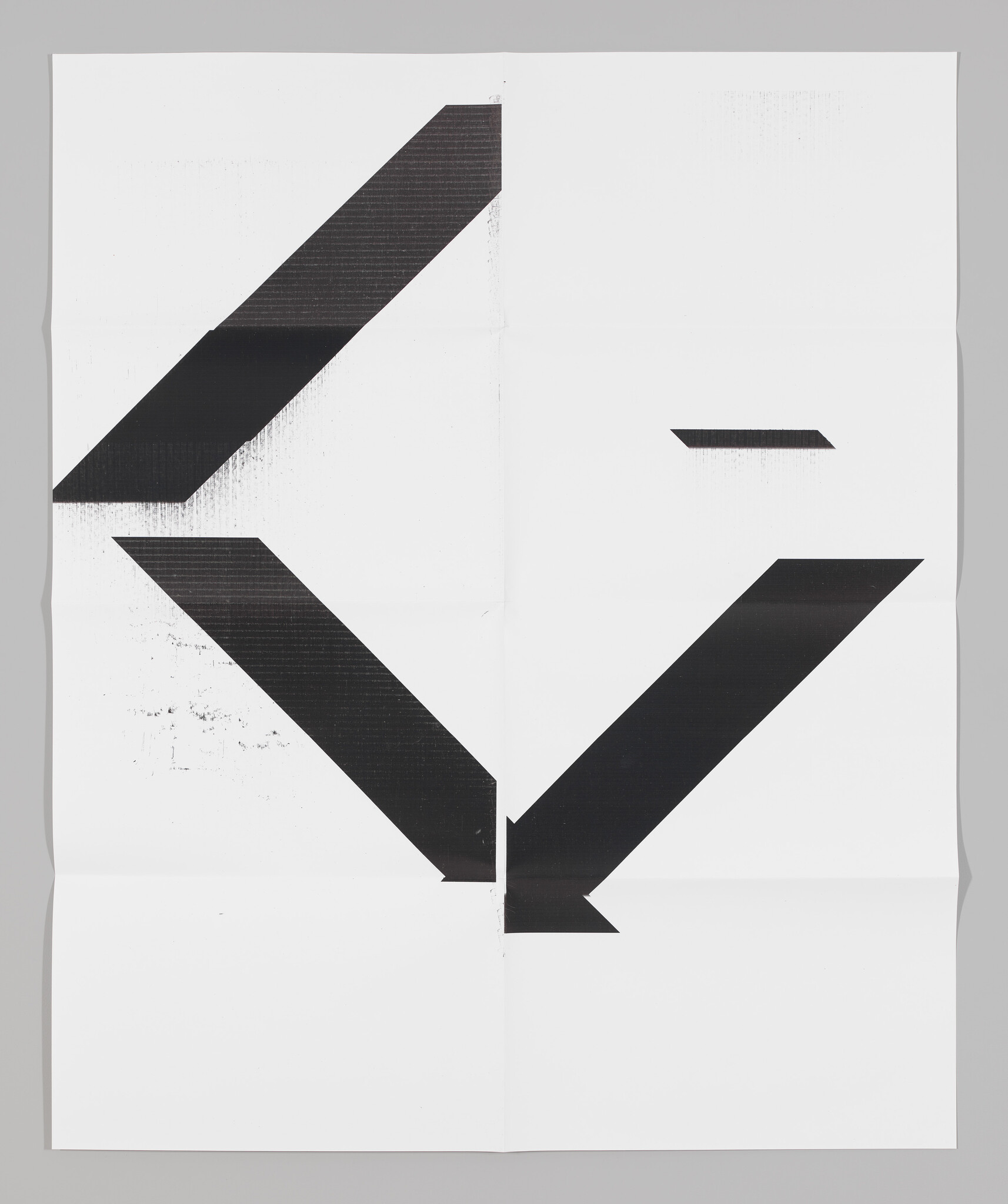 Large folded white paper showing bold black angular arrow shapes pointing downward and outward.
