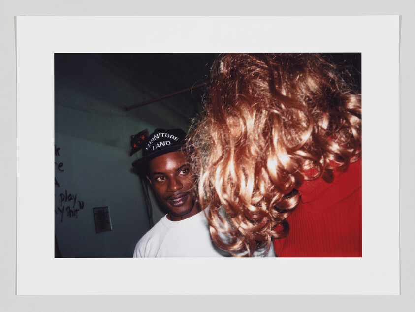 A dynamic shot with a Black man looking at a blond, curly-haired woman.