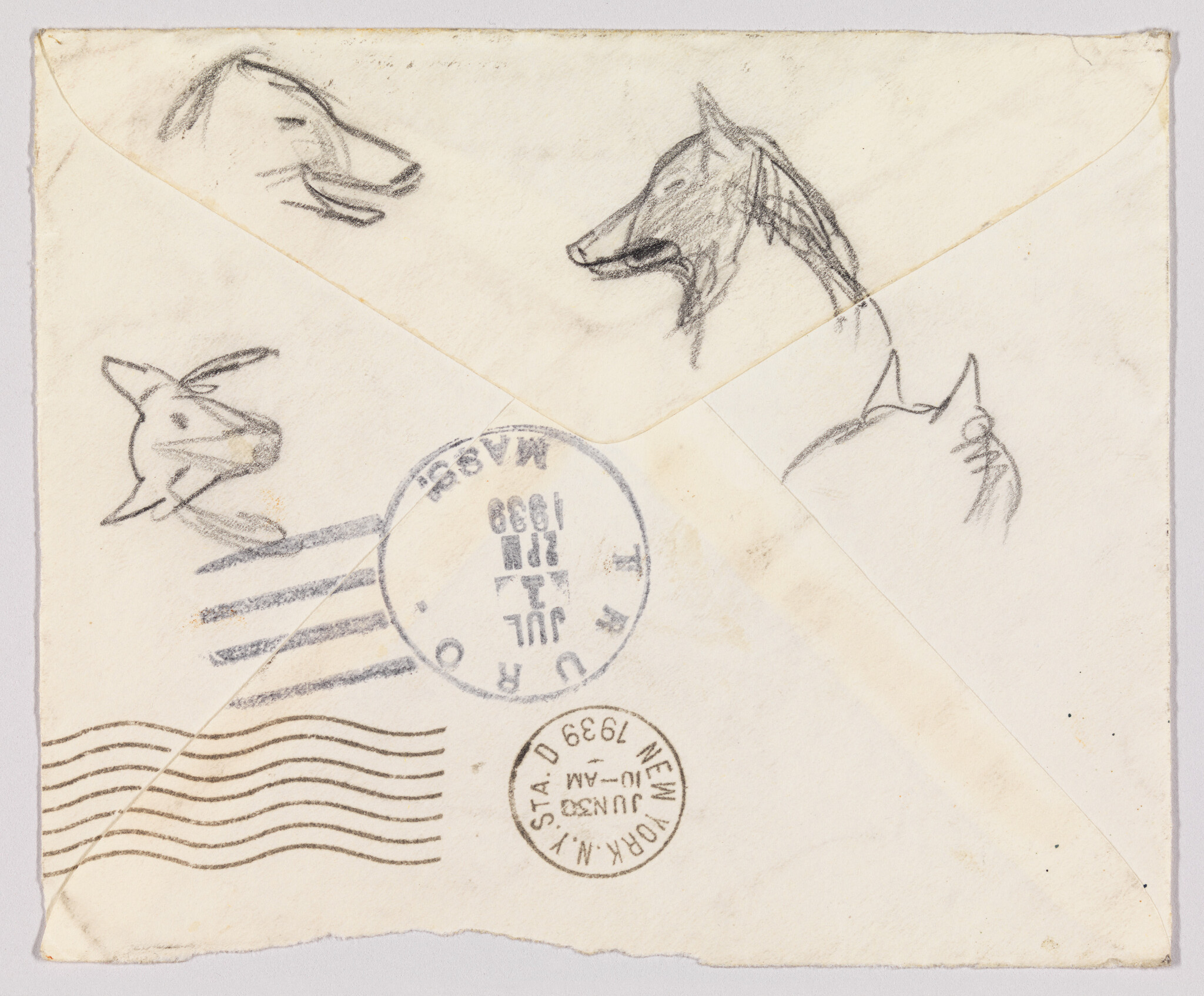 An old envelope with five pencil dog head sketches and two round postal stamps.