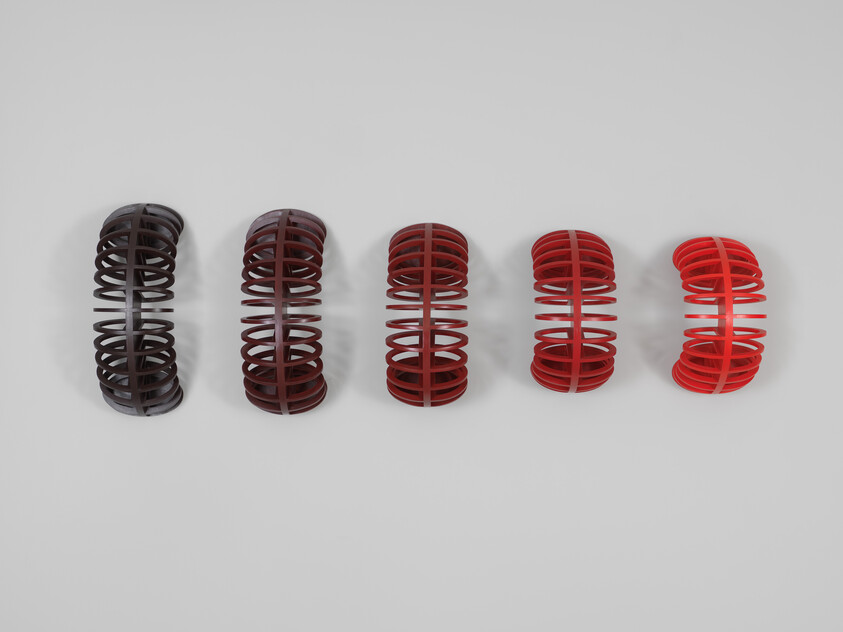 Five hollow coil rings sit in a row, shifting in color from dark brown to bright red.