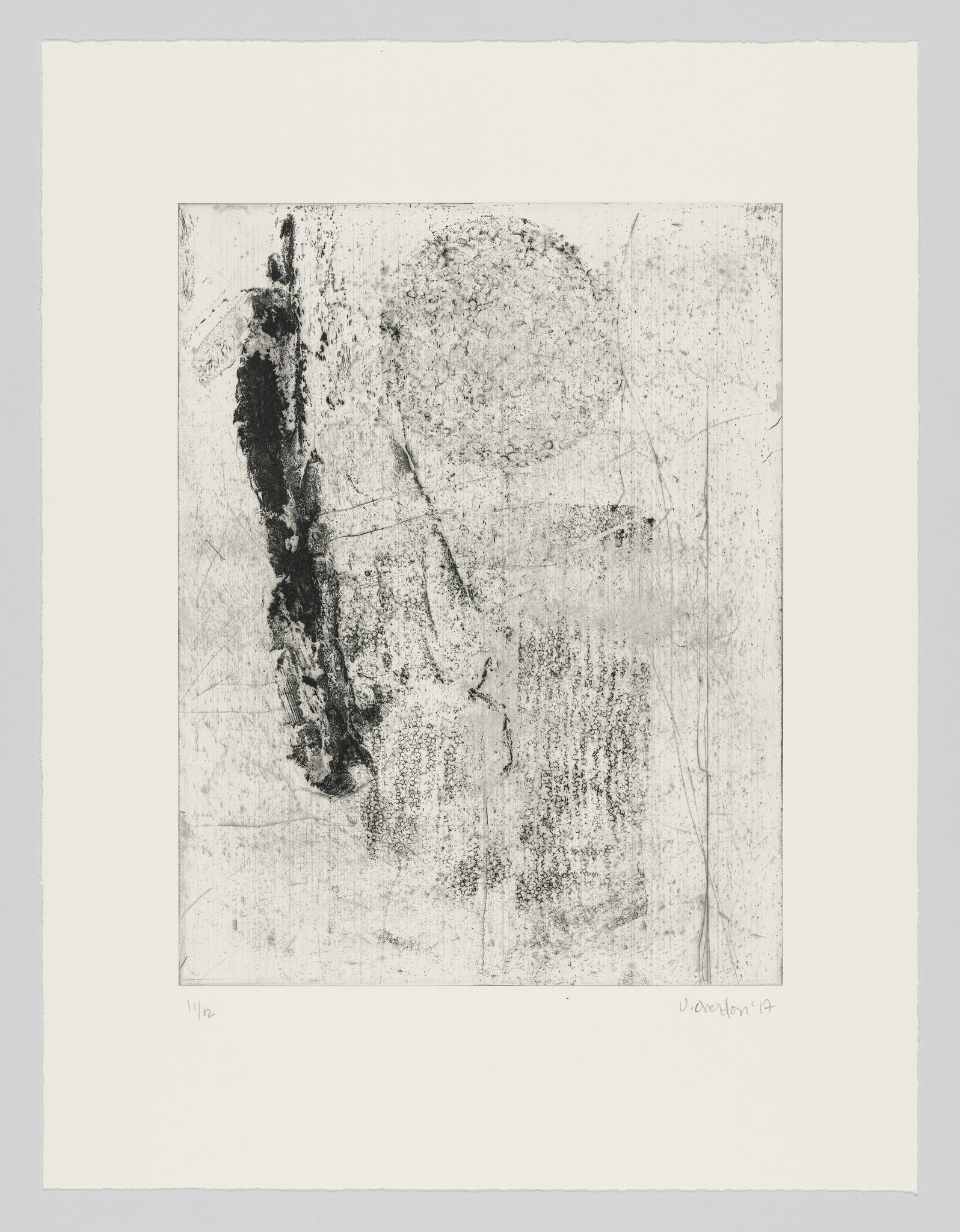 Abstract black textured vertical mark and faint circular pattern on a light paper background.