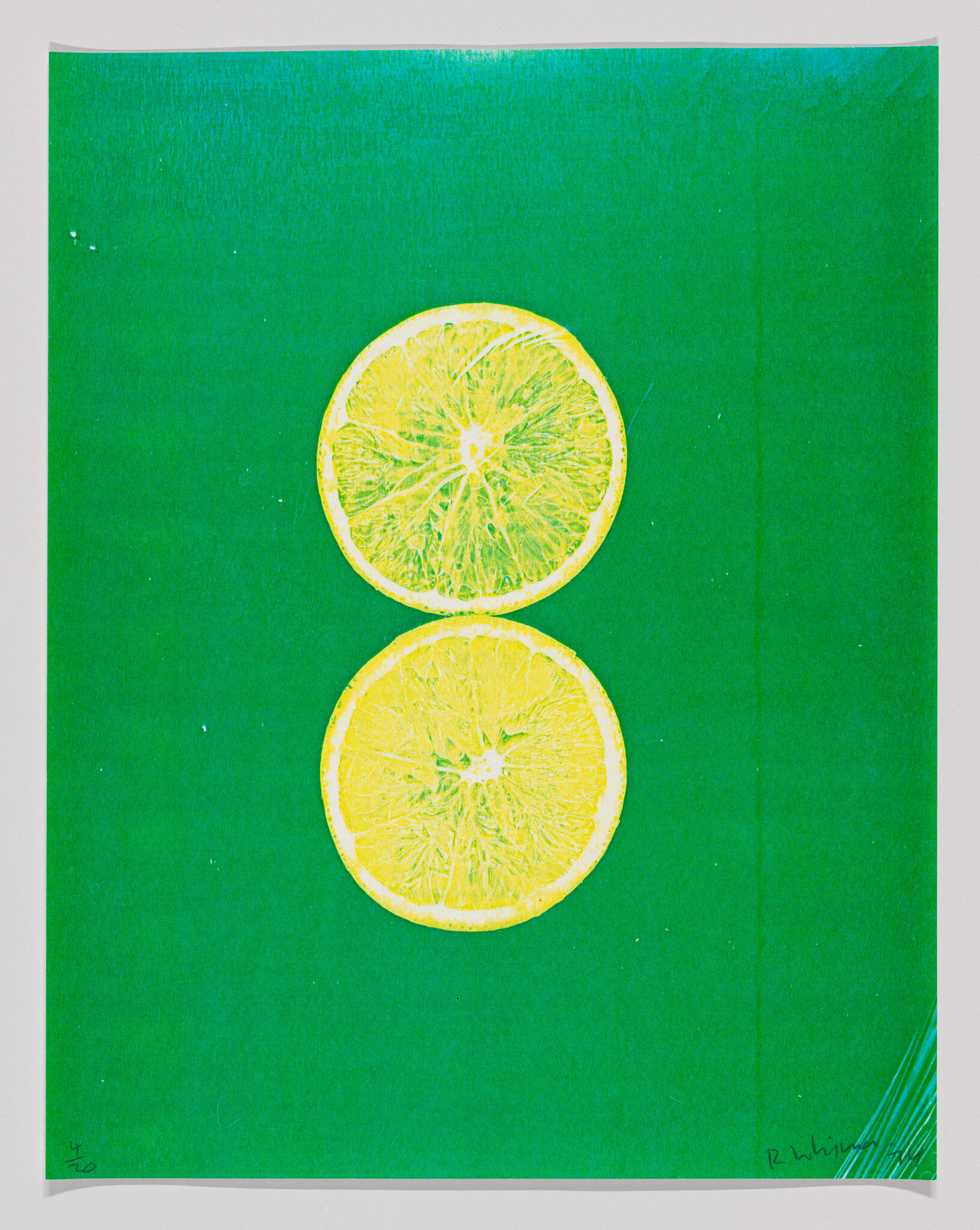 Two yellow lemon slices stacked vertically on a solid green background.