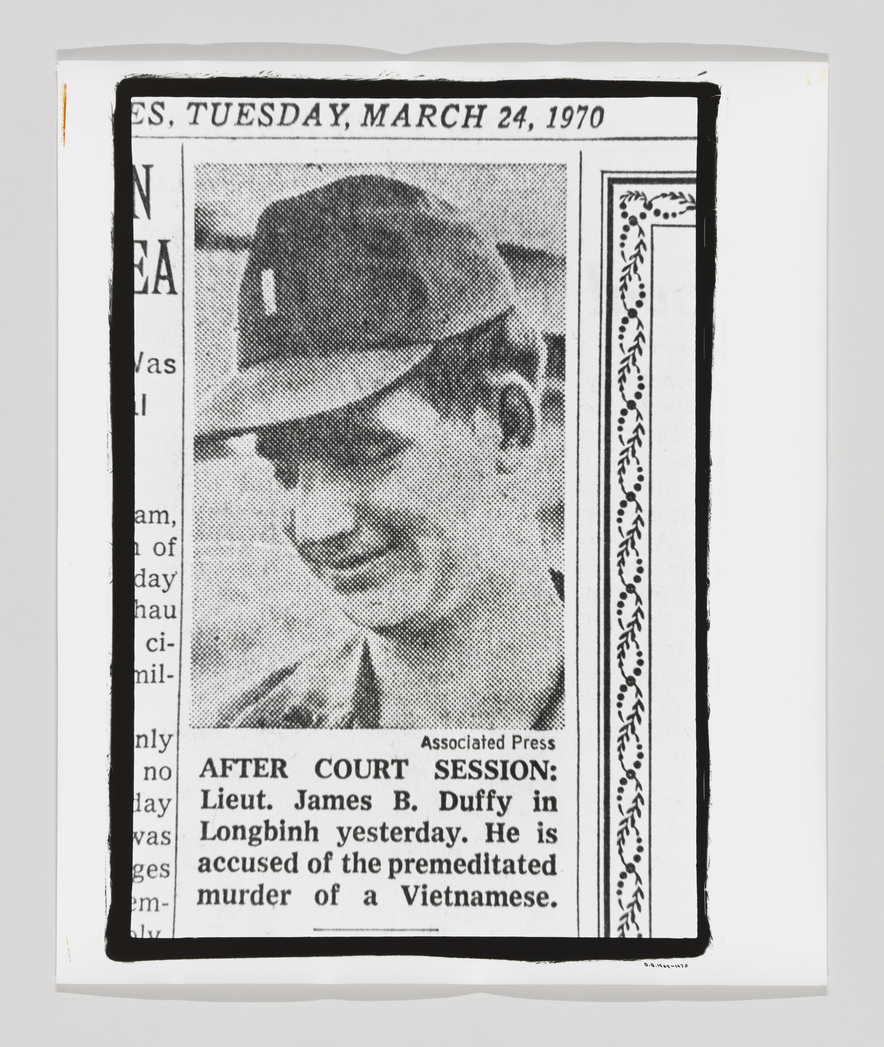 A black and white newspaper clipping from March 24, 1970, featuring a photograph of a man in a military cap with a caption that reads "AFTER COURT SESSION: Lieut. James B. Duffy in Longbinh yesterday. He is accused of the premeditated murder of a Vietnamese." The article is from the Associated Press and the image is bordered by a decorative frame on the right side.