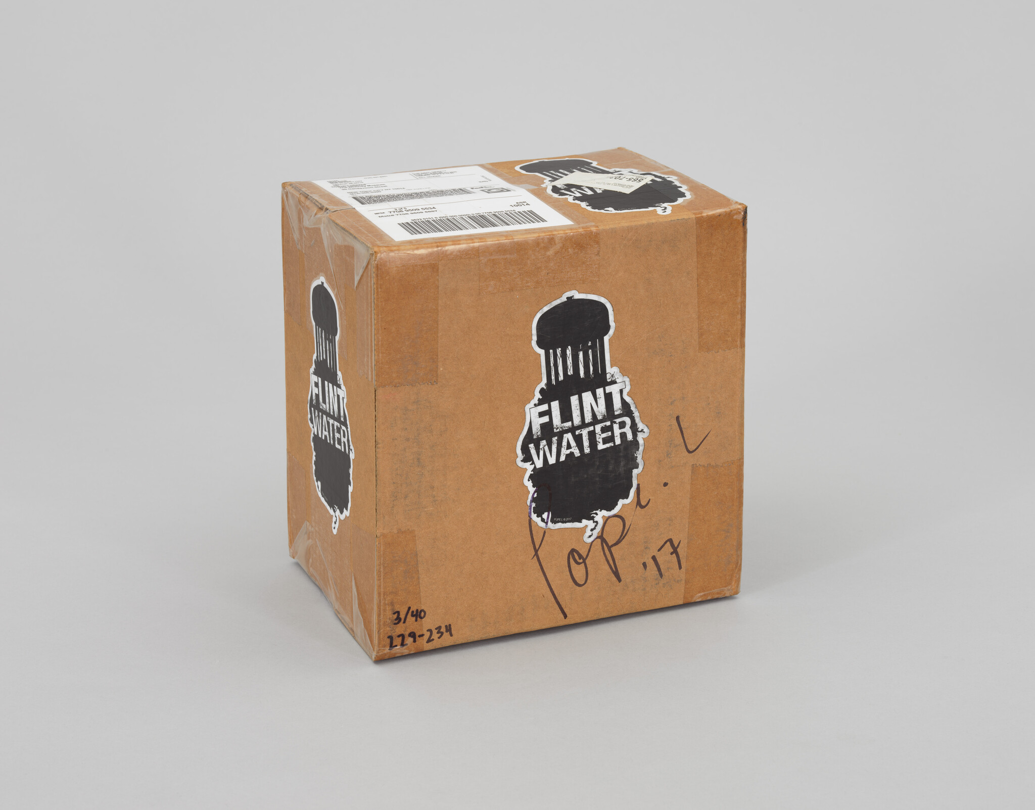 A cardboard box with "Flint Water" labels and a barcode, possibly related to the Flint water crisis.