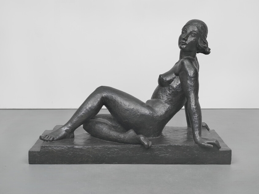 Bronze reclining female figure rests on one arm with legs extended on a rectangular base.