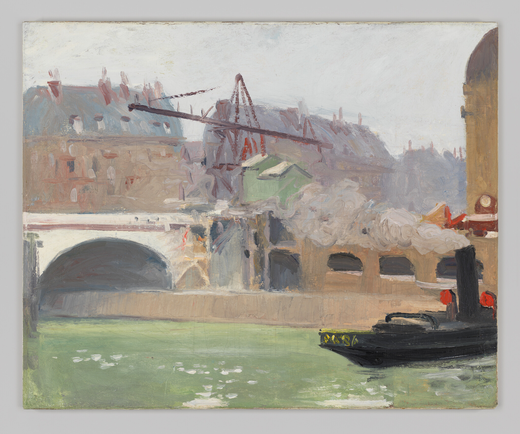 A small black steam tug emits smoke while passing a bridge and buildings along a green river.