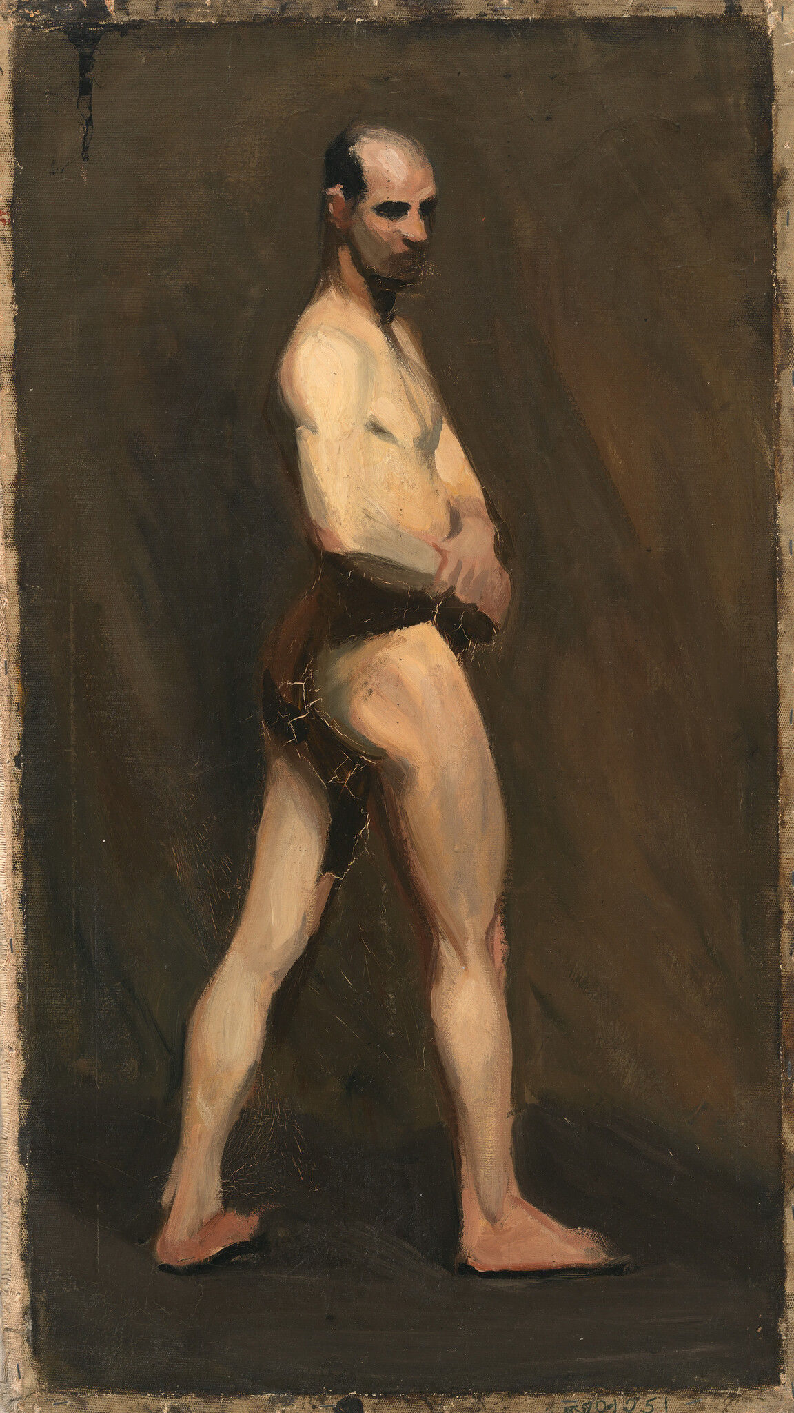 A standing man in a loincloth with hands on his abdomen, looking sideways.
