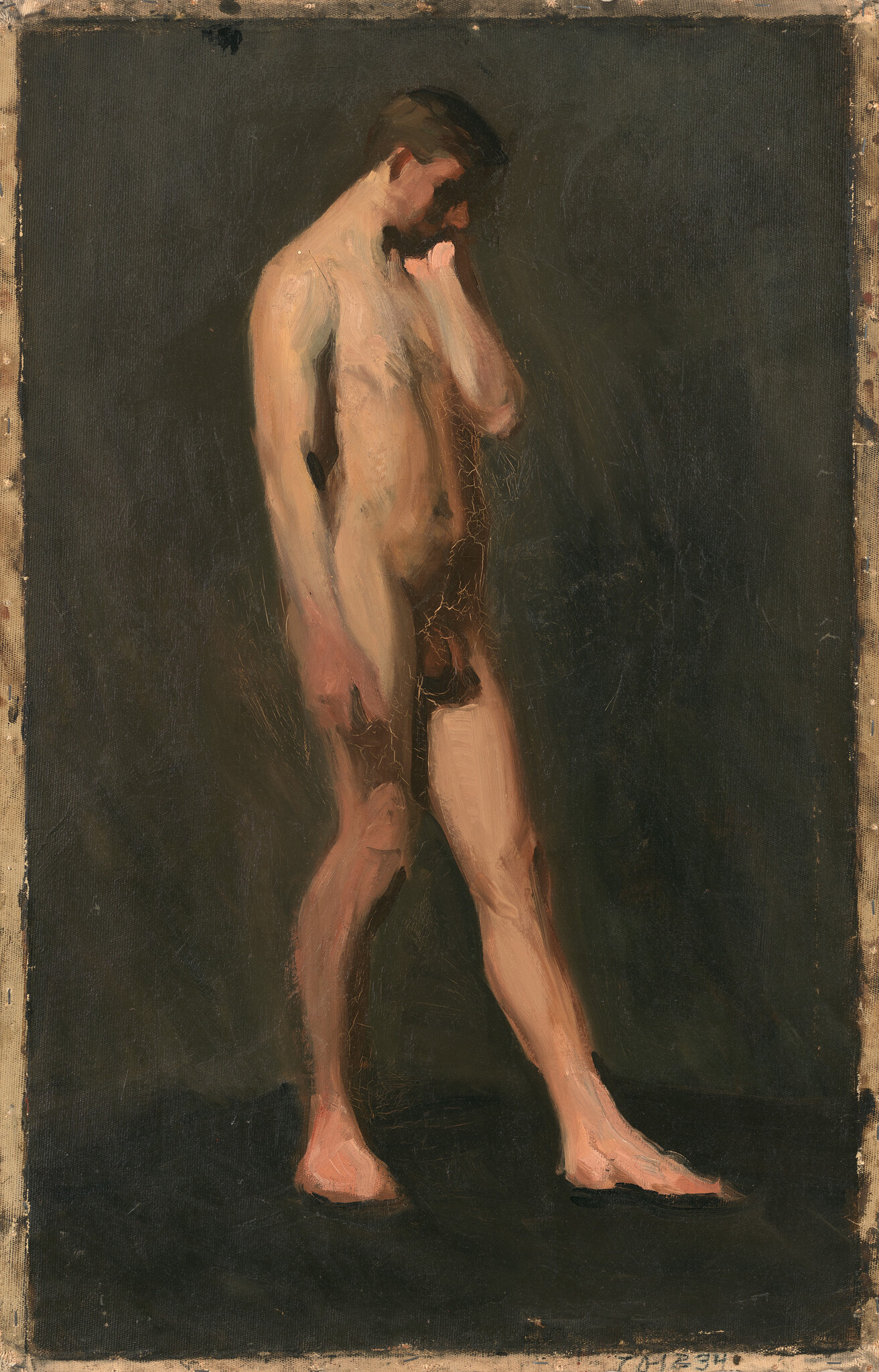 A nude young man stands with head bowed and hand touching his face, looking down.
