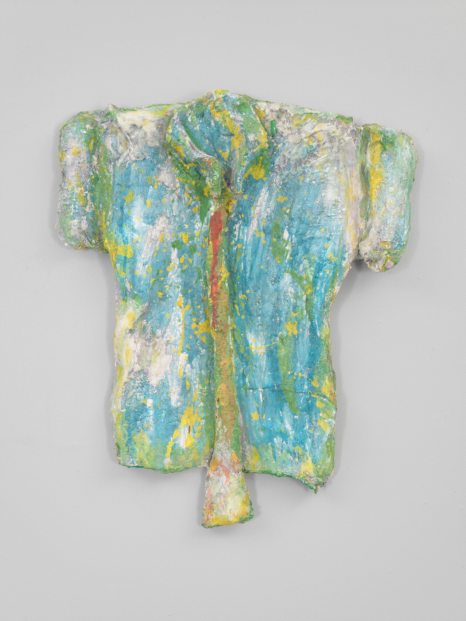 Abstract painted torso sculpture in blue, green, and yellow with a long drip-like protrusion.