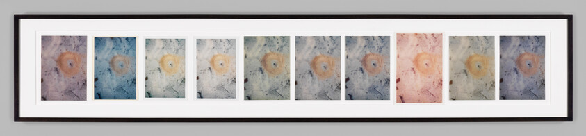 Long framed series of ten abstract prints with circular center motifs in varying colors.