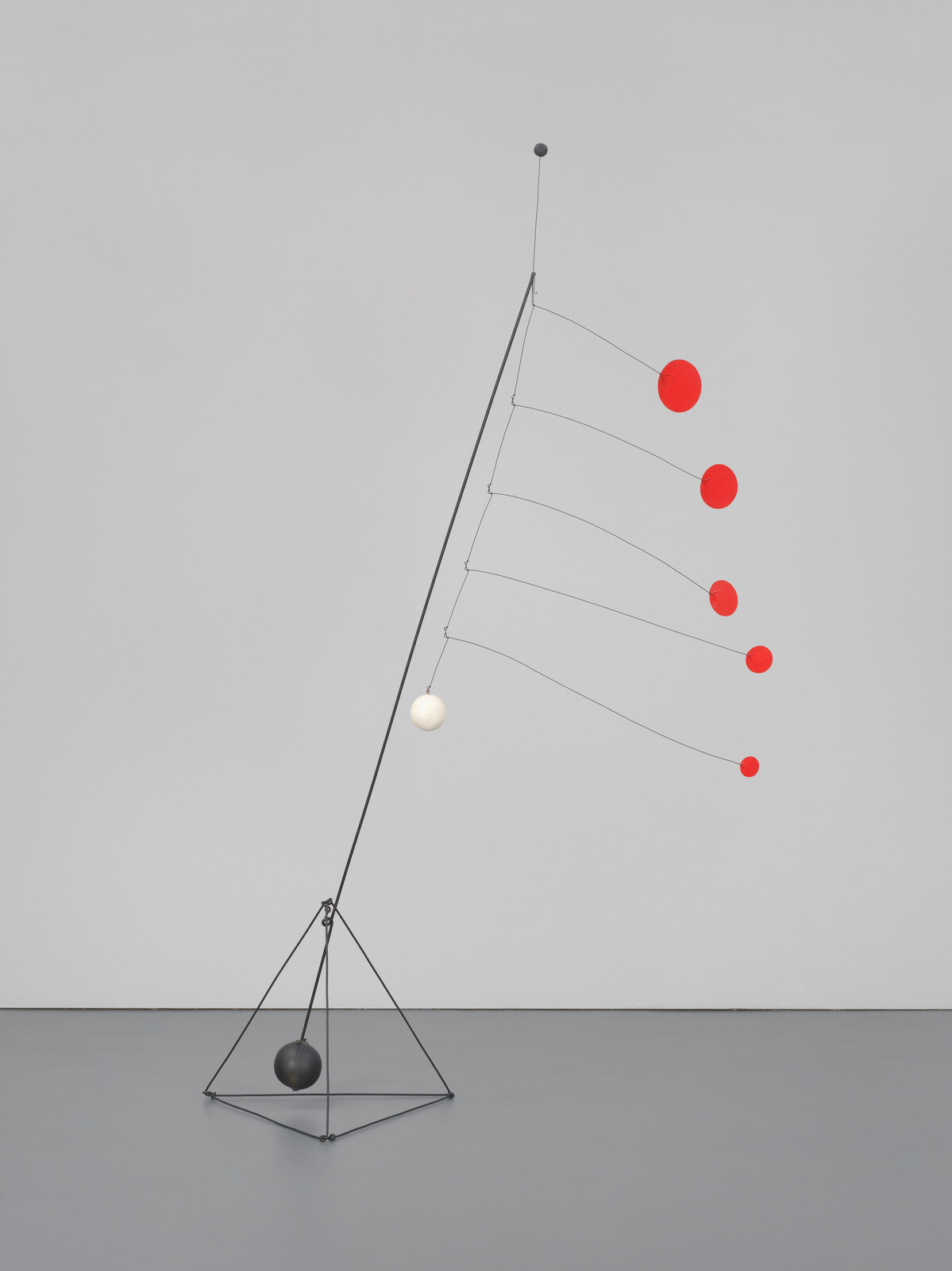 Tall balancing mobile sculpture with five red discs on thin wires and weighted black base.