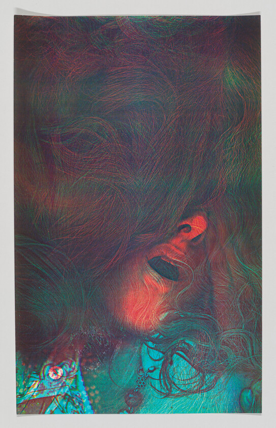 Person with long hair covering their face and mouth slightly open under colorful lighting.