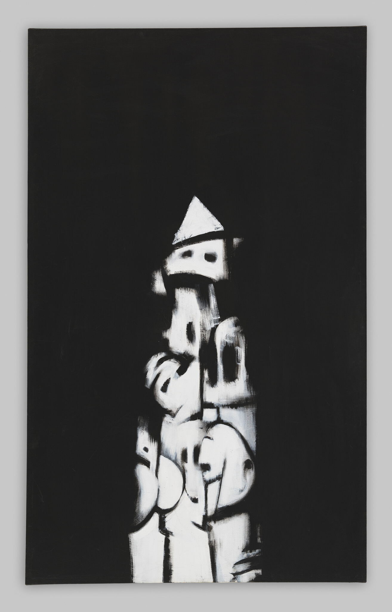 Against a black background, chalky organic shapes stack to form a totem-like structure.