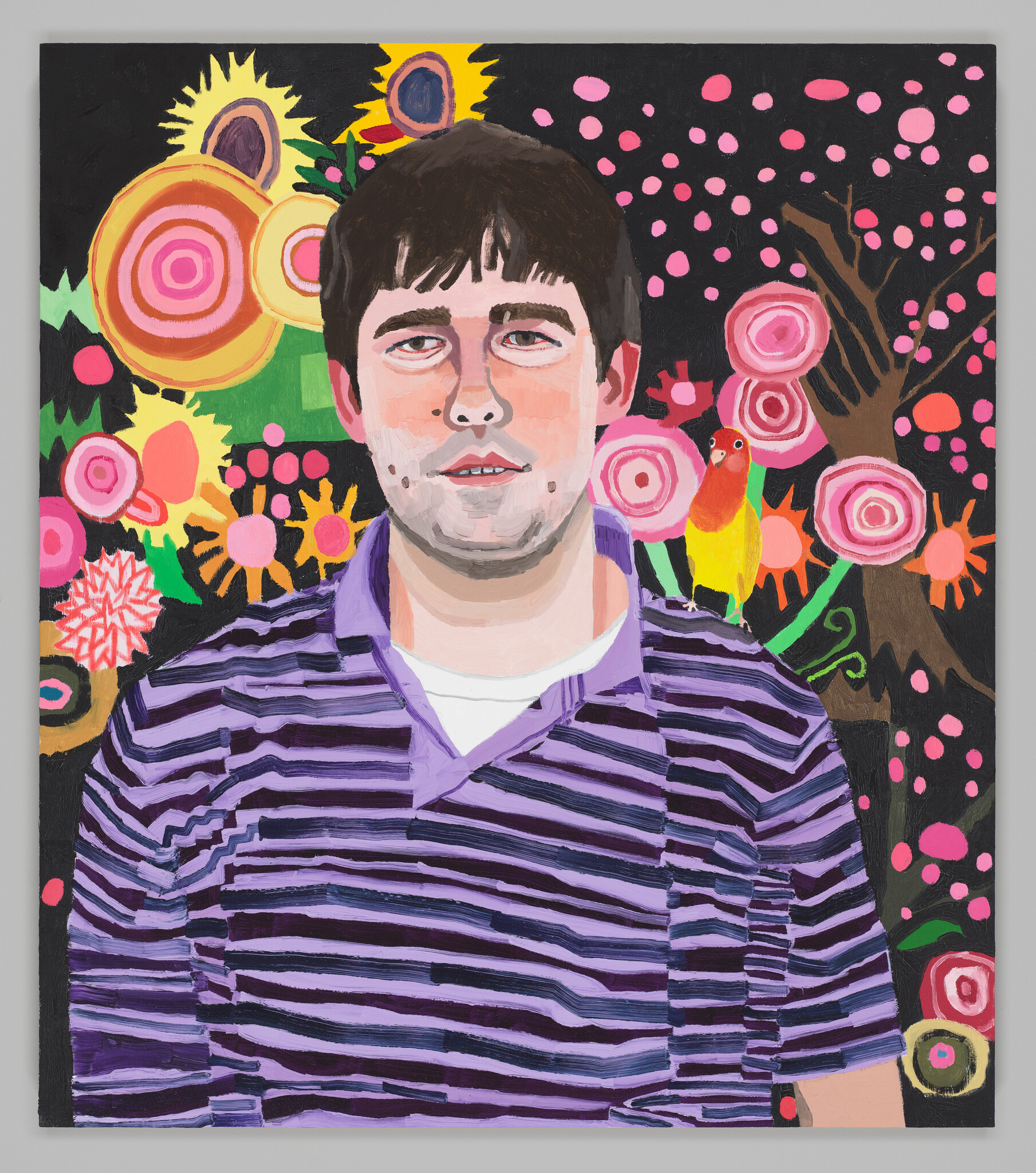 A man in a striped polo has a parrot on his right shoulder aganist a vibrant background of organic flower shapes