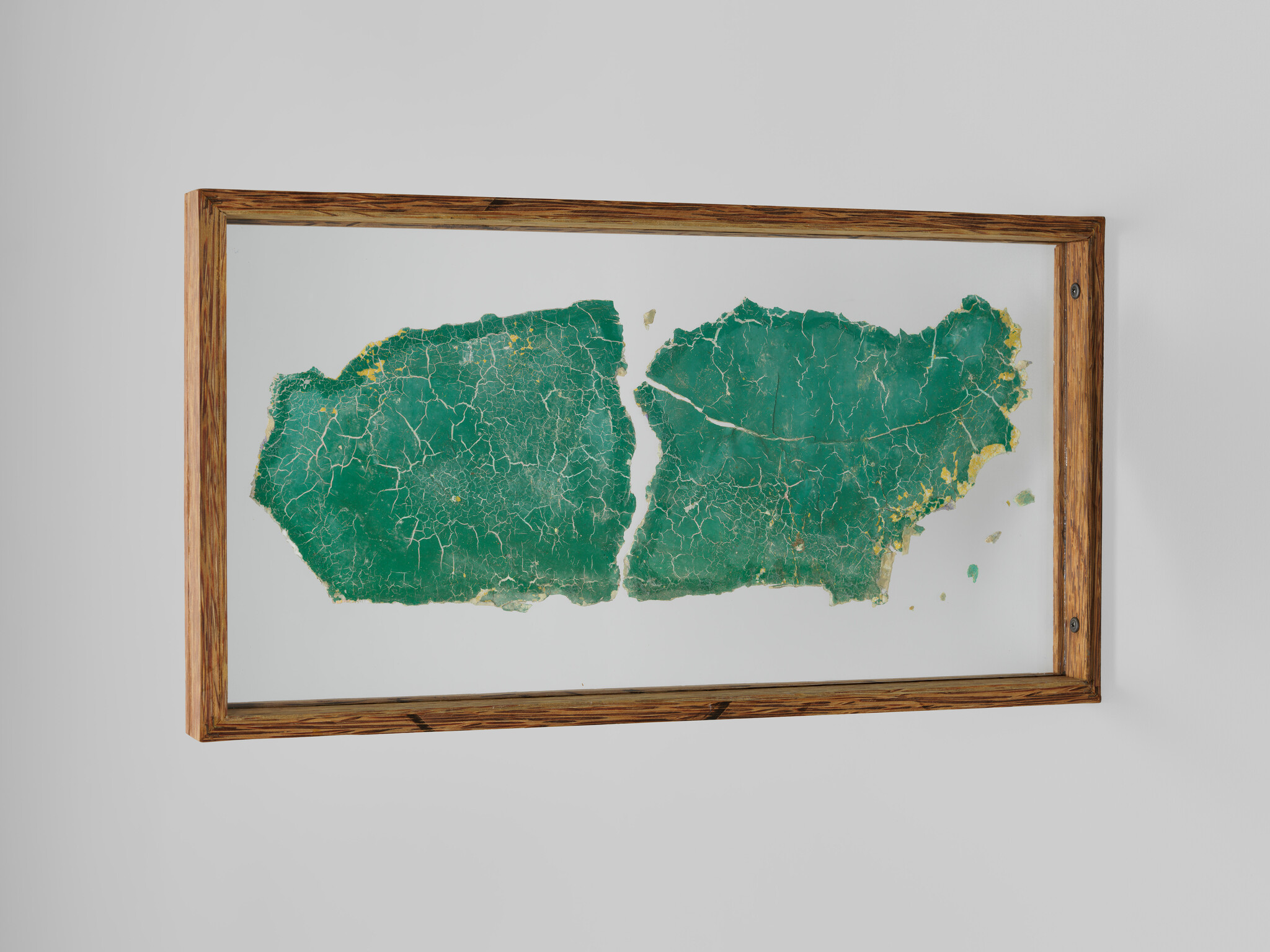 Framed map-like artwork showing two cracked green panels with gold flecks on a white background.
