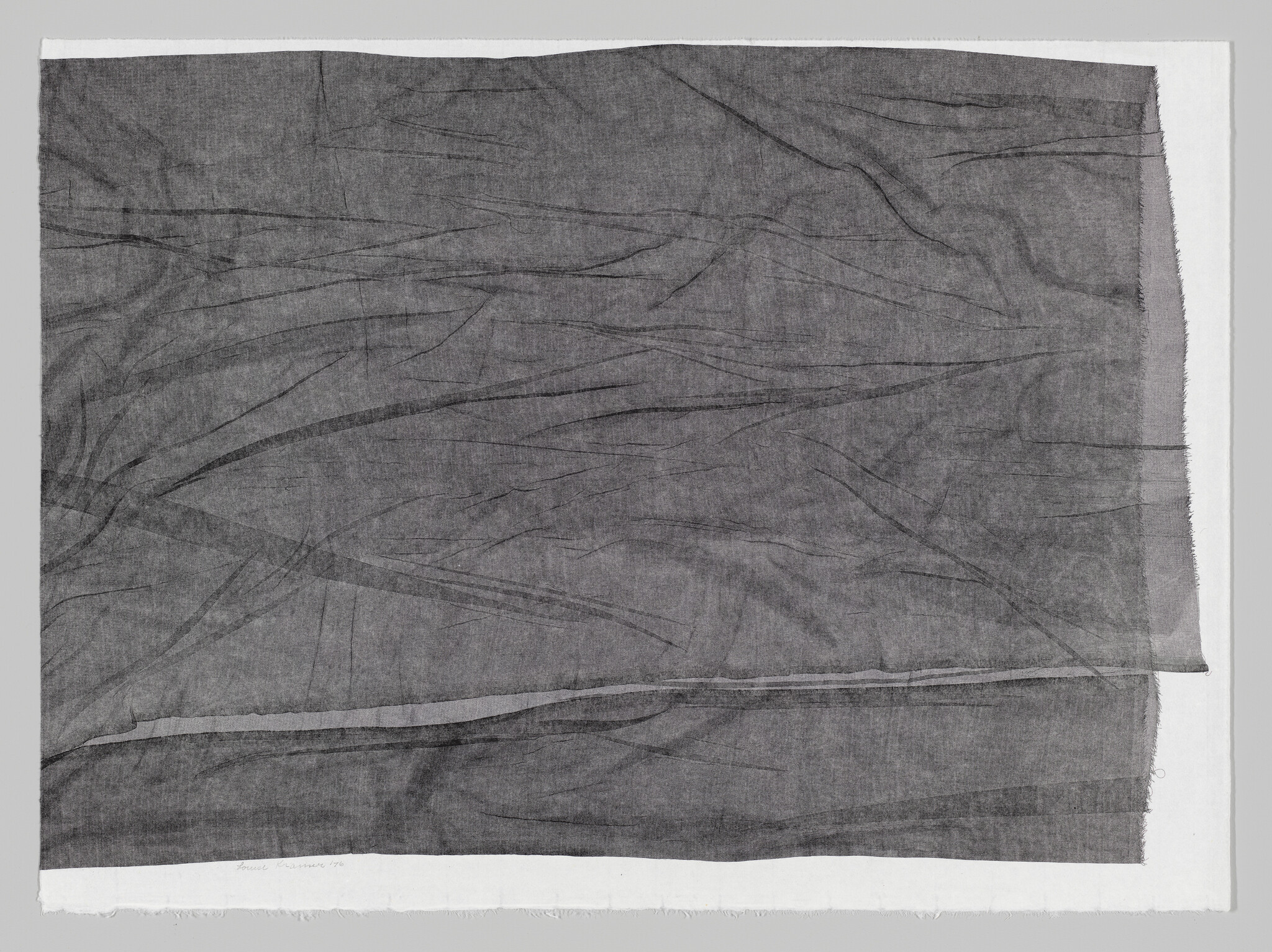 A large wrinkled gray cloth laid flat with subtle folds and frayed edges.