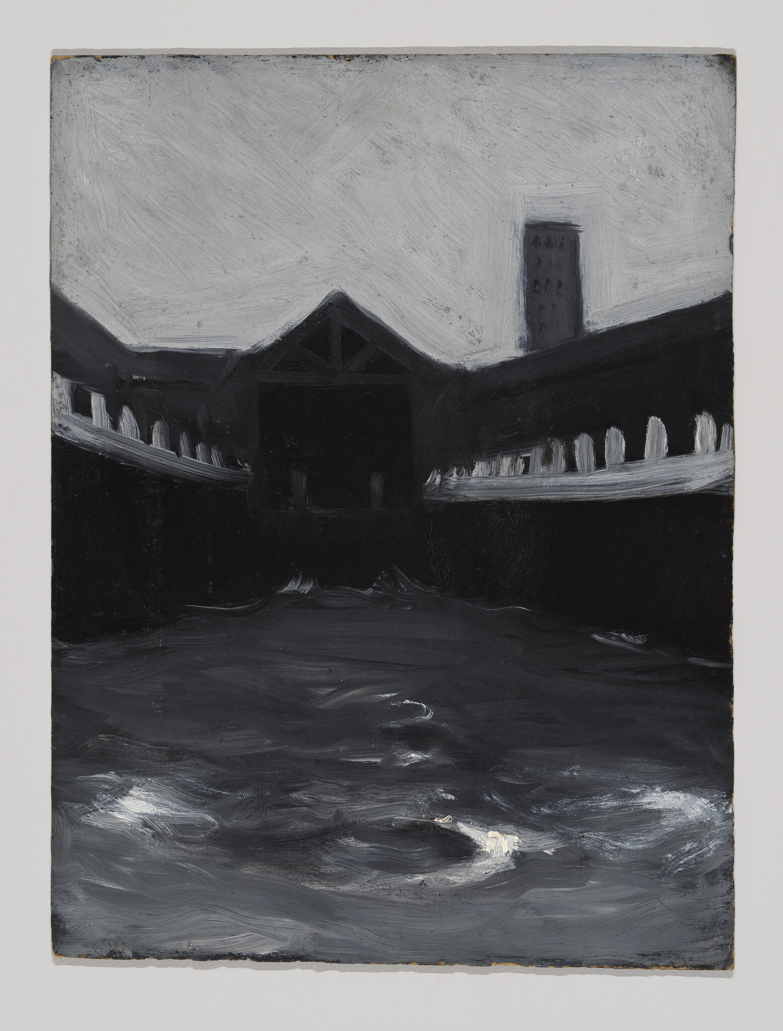 Dark waterfront courtyard with choppy water in the foreground and silhouetted buildings and tower.