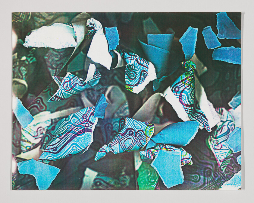 Torn blue and patterned paper pieces scattered across a dark textured background.