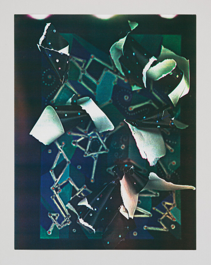 Torn black and white paper curls scattered over a blue geometric patterned background.