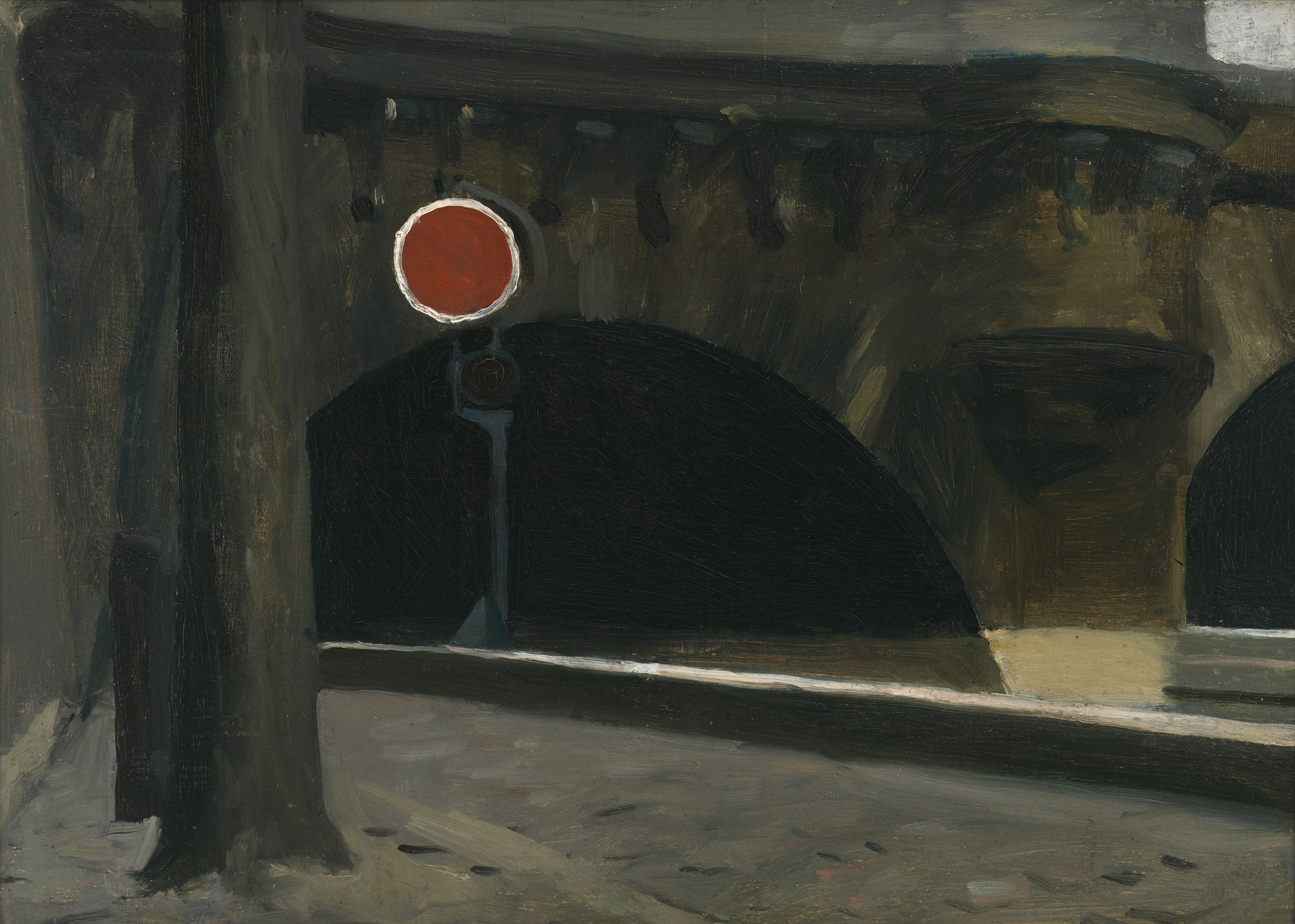 The arched entryway of a dark tunnel behind a bright red, round traffic sign.