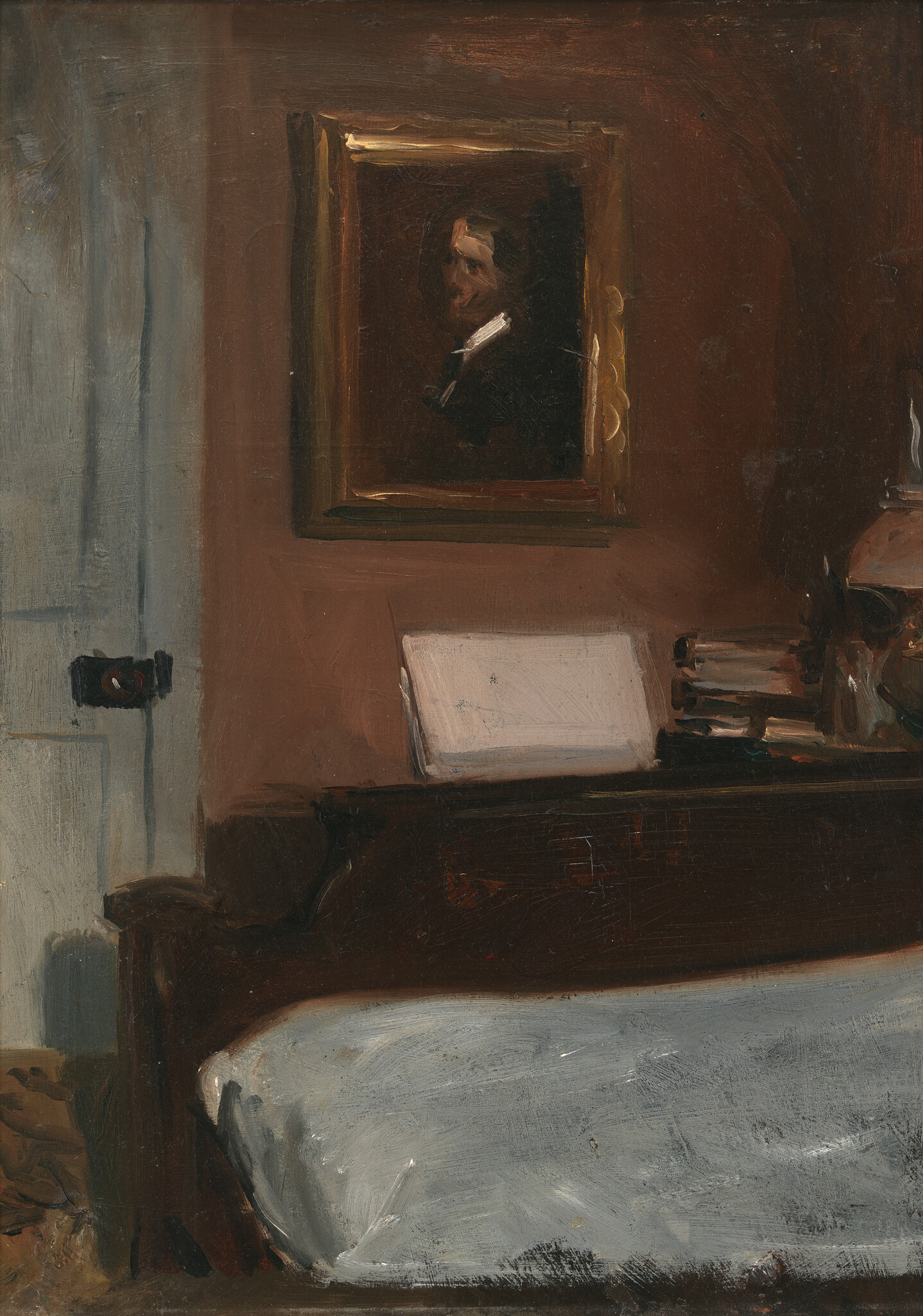 A simple bedroom with a bed, headboard topped by books and a framed portrait.