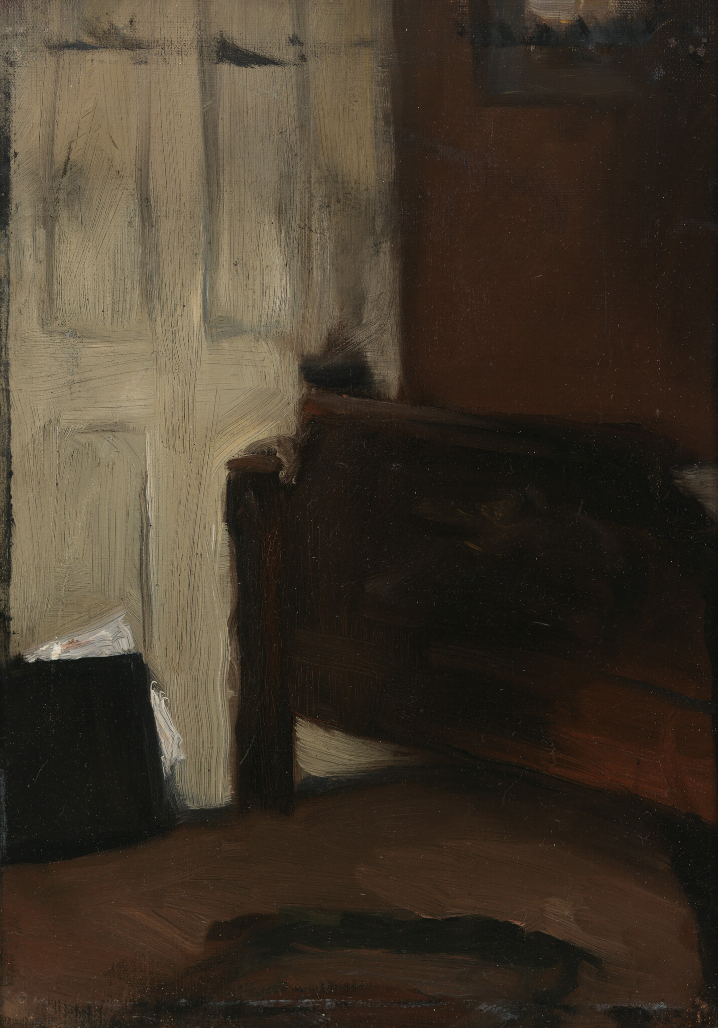 A dark wooden chair sits beside a pale closed door in a dim room.