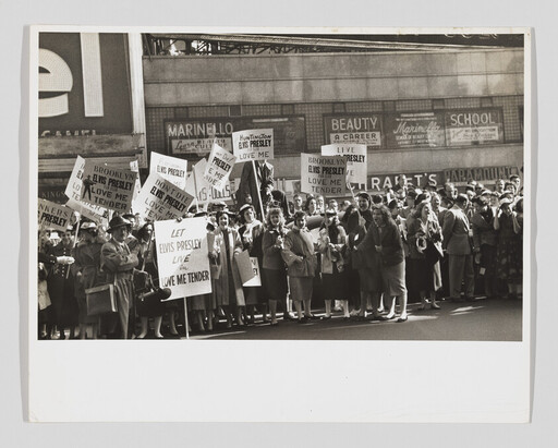 A large crowd of fans holding signs urging support for Elvis Presley and "Love Me Tender."